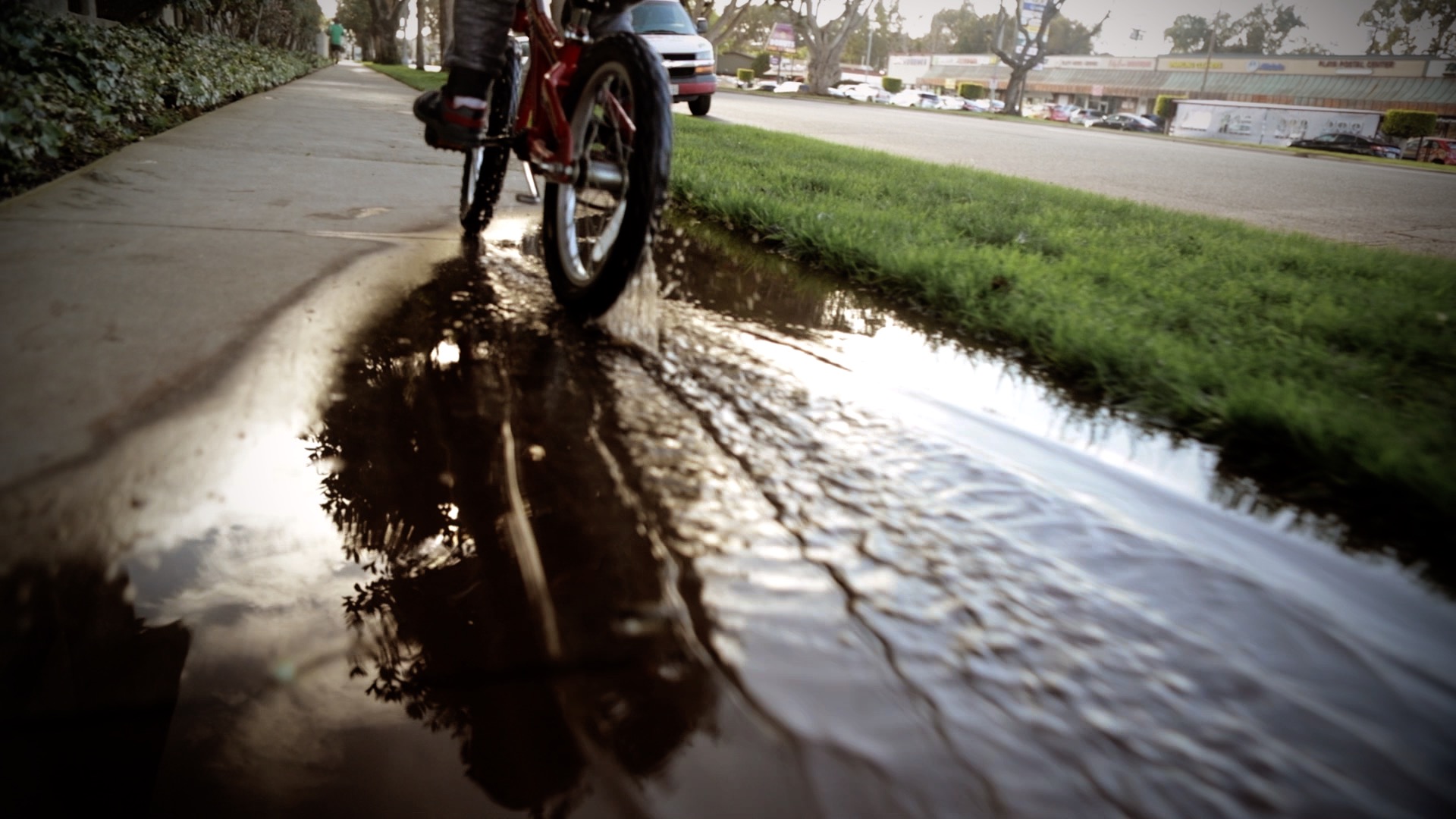 the wheels of a bike going through a puddle