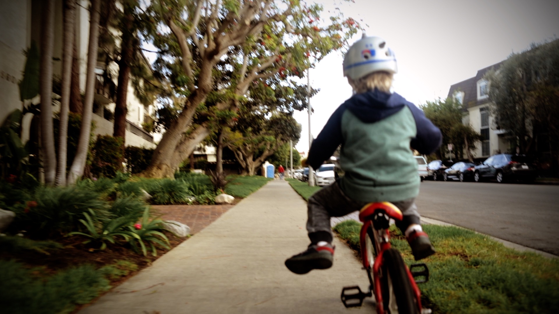 a boy lifting his feet while riding his bike