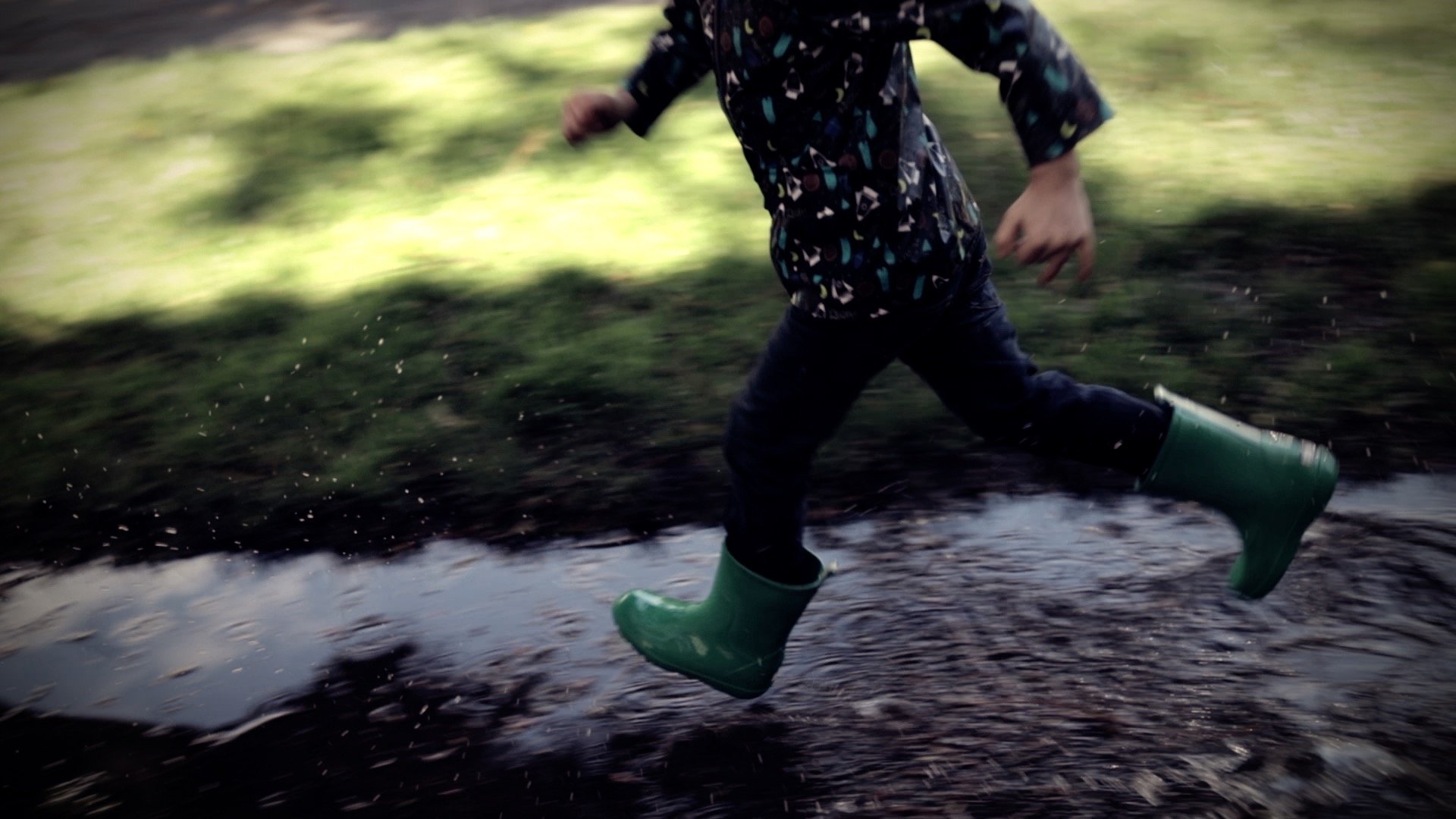 a boy running in a puddle